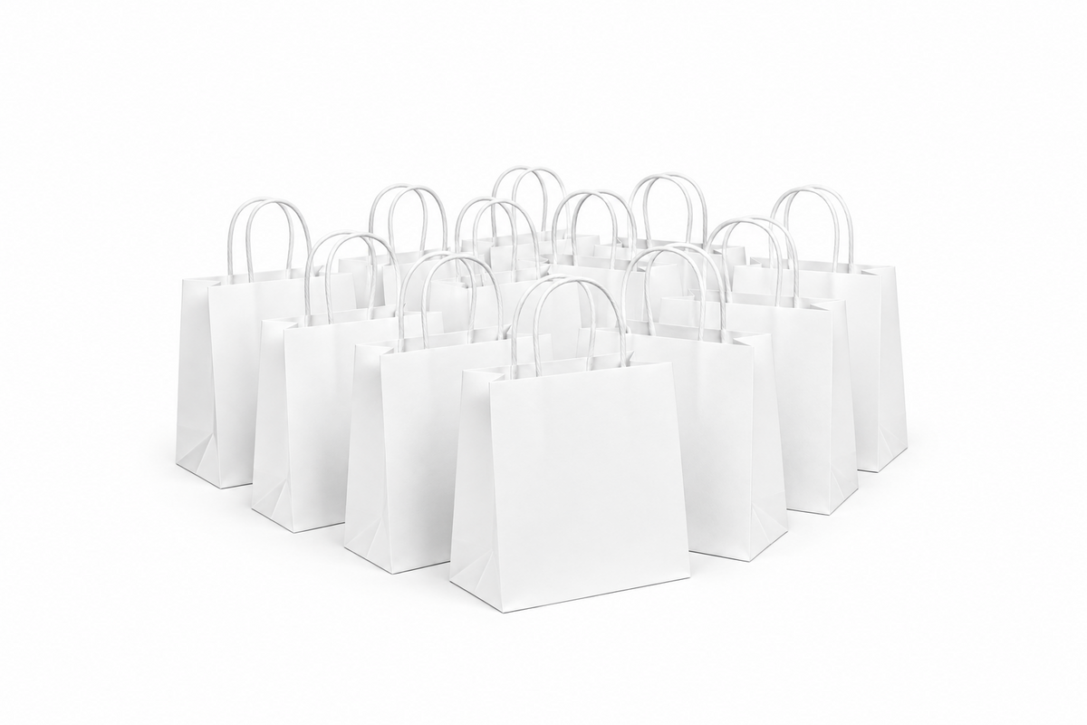 A group of blank white paper shopping bags with white handles, arranged in a cluster on a seamless white background.