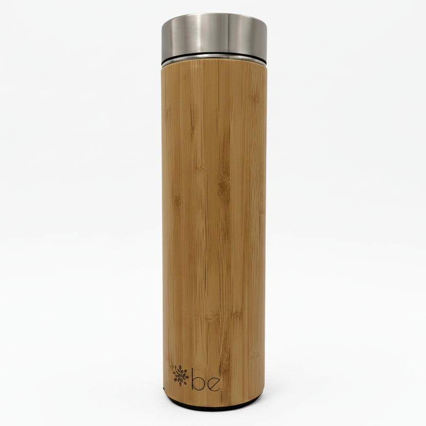 A tall bamboo insulated tumbler with a brushed stainless steel lid, standing upright on a clean white background. The brand name 'be' is printed near the bottom.