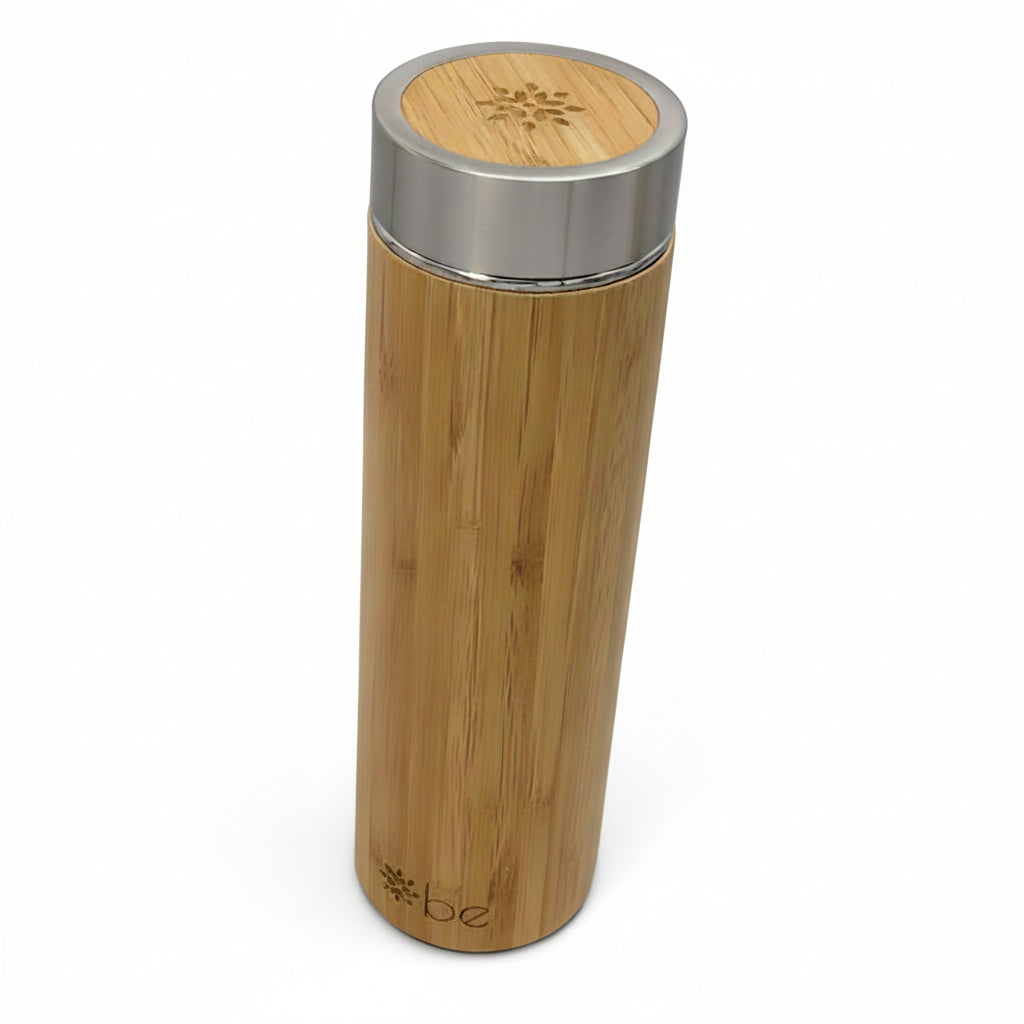 A bamboo insulated tumbler with a brushed silver metal lid, featuring the 'be' logo near the bottom, shown on a plain white background.