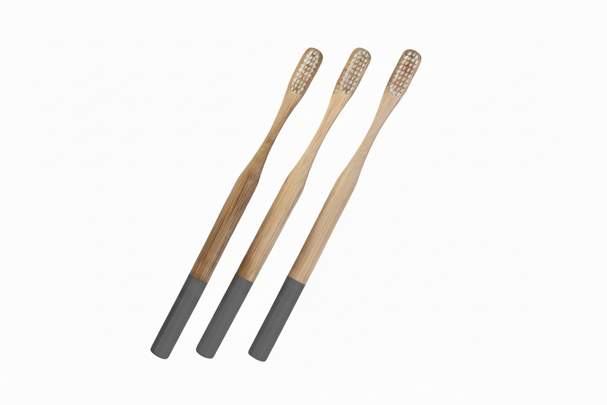 Three bamboo toothbrushes with dark gray handles, arranged diagonally on a plain white background.
