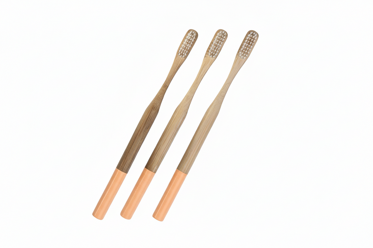 Three bamboo toothbrushes with natural wood handles and light-colored bristles, arranged diagonally on a plain white background.