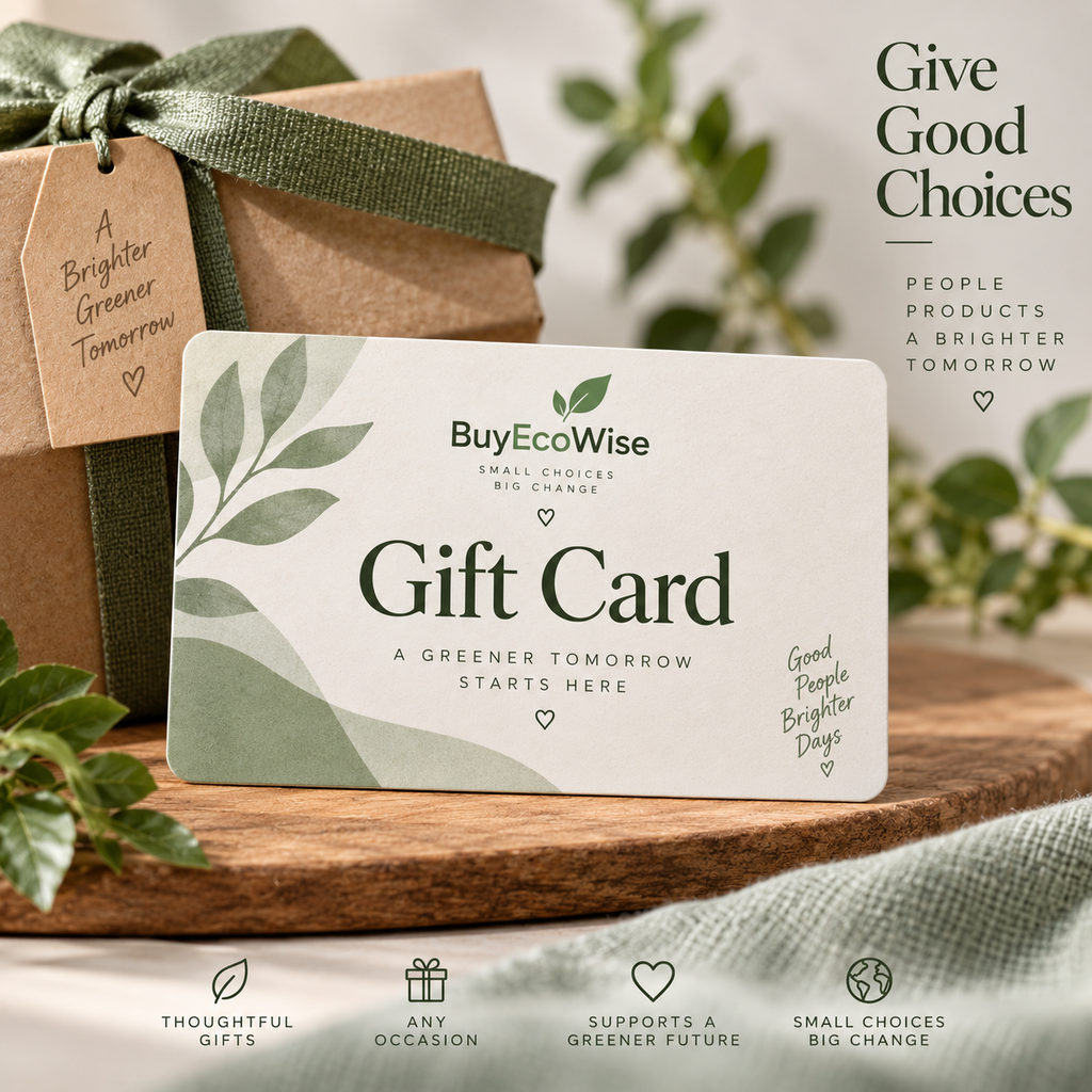A BuyEcoWise gift card is displayed on a wooden surface in a styled setting with a kraft gift box, green ribbon, leaves, and soft neutral fabric. The card reads 'Give Good Choices' and 'Gift Card,' with additional promotional text around it.