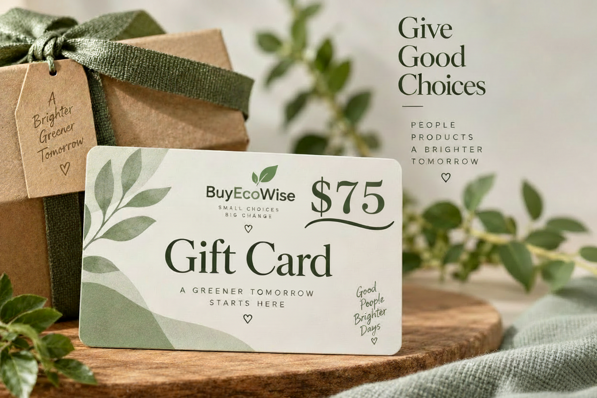 A BuyEcoWise $75 gift card displayed on a wooden surface next to a brown kraft gift box tied with a green ribbon. The scene includes soft-focus greenery and text on the right reading 'Give Good Choices People Products A Brighter Tomorrow.