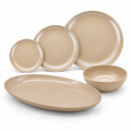 HUSKSWARE five-piece rice-husk dinnerware set with small, medium and large round plates, a large oval serving plate and one bowl on a white background.